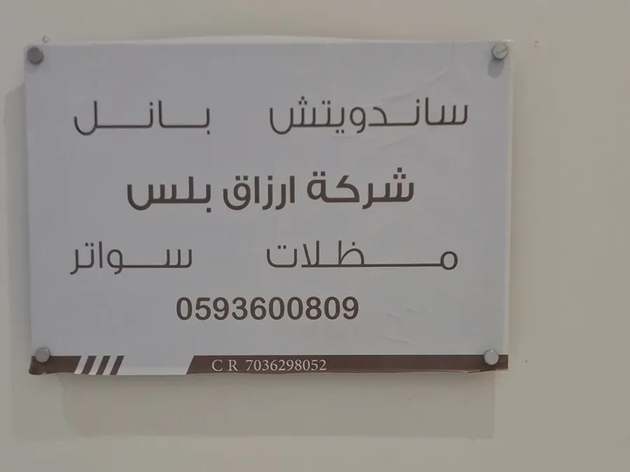 لوحة شركة أرزاق بلس تعرض خدمات ساندوتش بانل ومظلات وسواتر ورقم التواصل