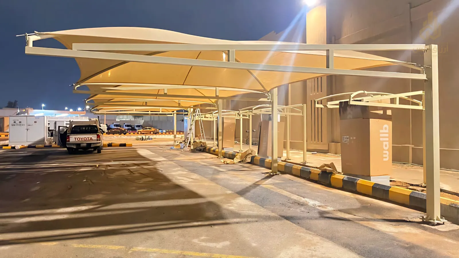 مظلات سيارات ممتدة على موقف مضاء في الرياض