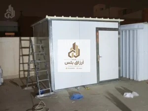 غرفة ساندوتش بانل مكتملة التركيب في فناء ليلًا
