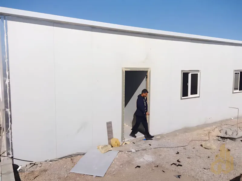 مبنى ساندوتش بانل بواجهة بيضاء في موقع مشروع