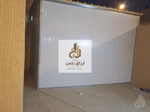 جدار مكسو بألواح ساندوتش بانل بيضاء في موقع ليلًا