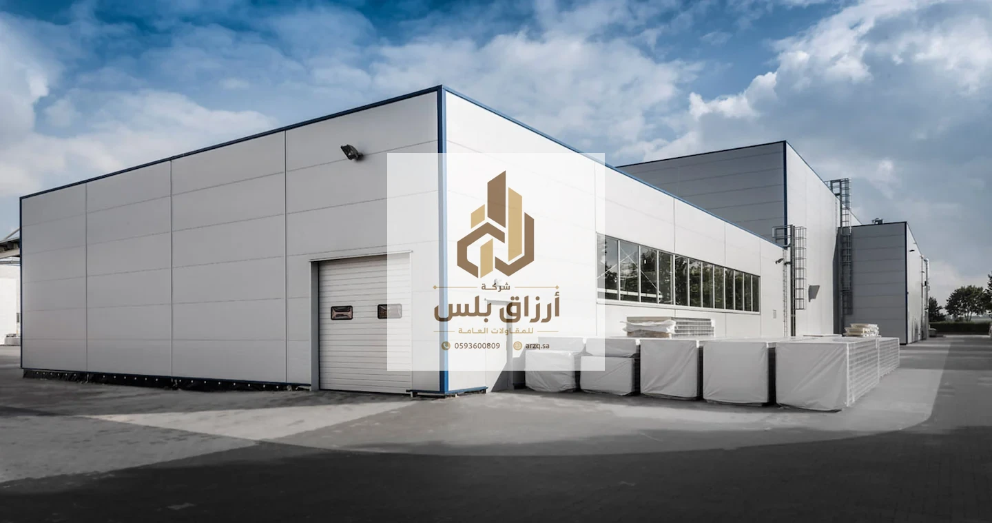 وحدة صناعية حديثة بواجهة ألواح مستوية وباب رول معدني وشرائح نوافذ وحواف زرقاء