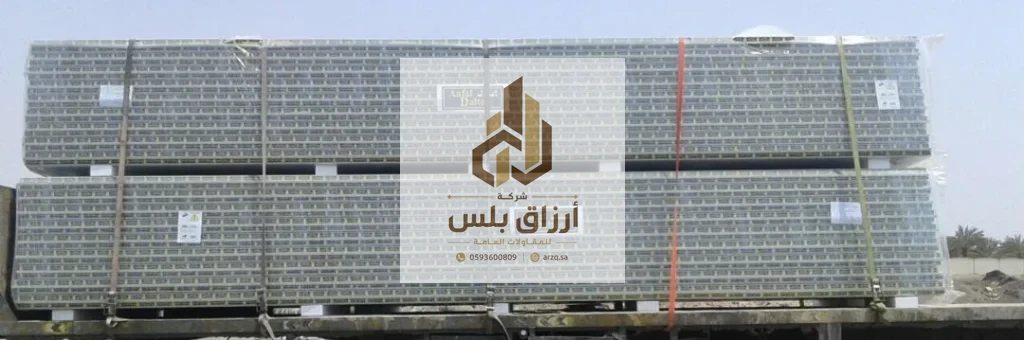 رزمتان طويلتان من ألواح الساندوتش بانل مغلّفتان ومربوطتان بأشرطة وتحملان بطاقات بيانات في ساحة تخزين