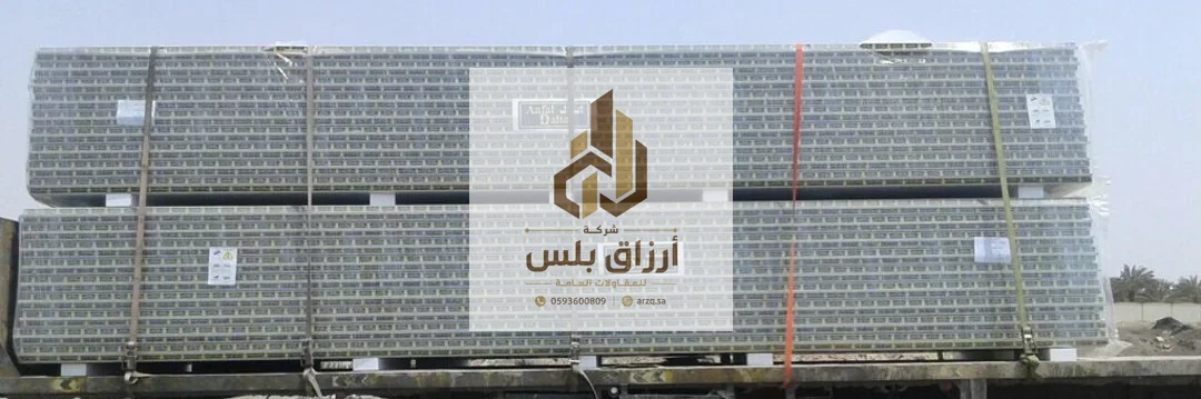 رزمتان طويلتان من ألواح الساندوتش بانل مغلّفتان ومربوطتان بأشرطة وتحملان بطاقات بيانات في ساحة تخزين