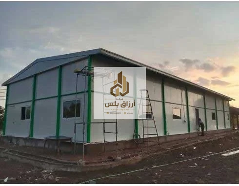 مبنى من ألواح معزولة بأعمدة معدنية خضراء وسقف جمالوني قيد التنفيذ مع سقالة وسلّم عند الغروب