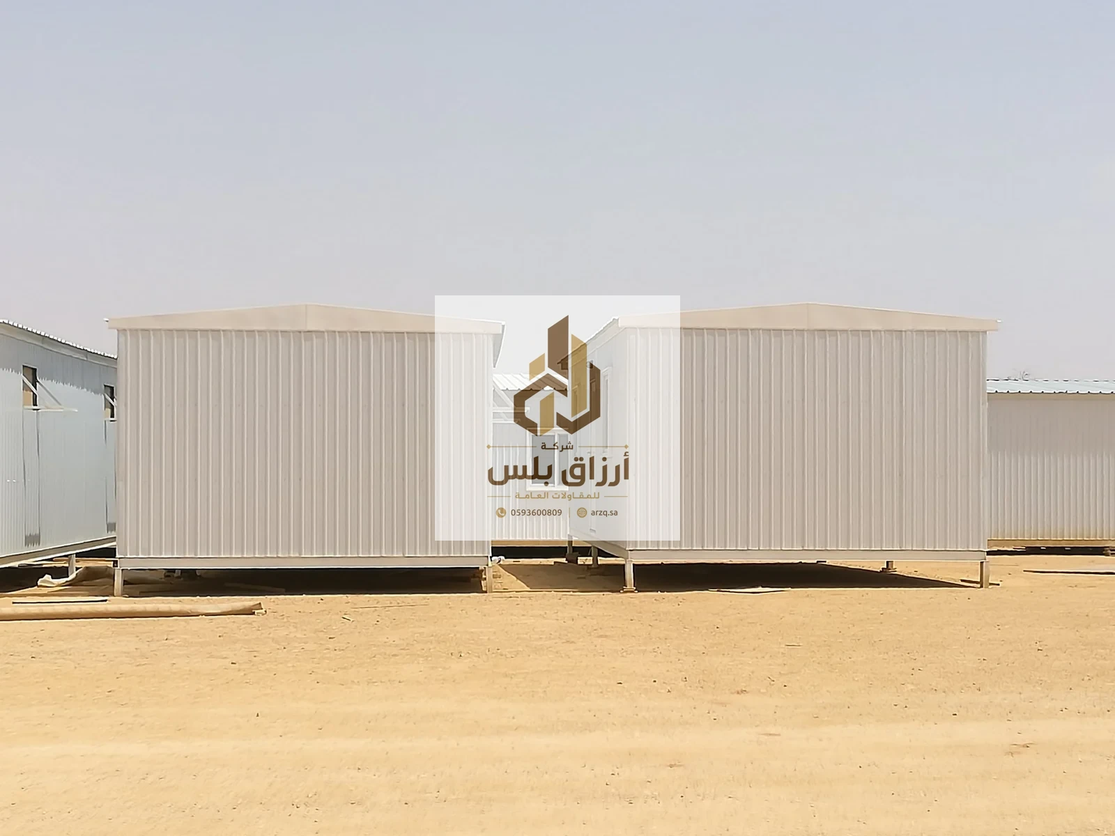 وحدتان متنقّلتان من ألواح معزولة بسقفين منحنيين مرفوعتان على قواعد معدنية على أرض ترابية