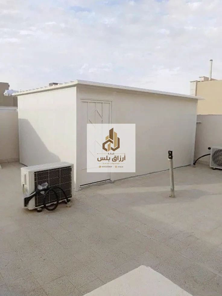 غرفة ساندوتش بانل مكتملة على سطح، بابها فاتح اللون ووحدة تكييف سبليت مثبتة على جدارها الخارجي