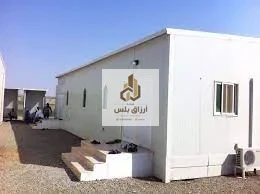 مكتب موقع من ألواح الساندوتش بانل بباب ونوافذ ووحدة تكييف سبليت ودرجات خرسانية على أرض ترابية