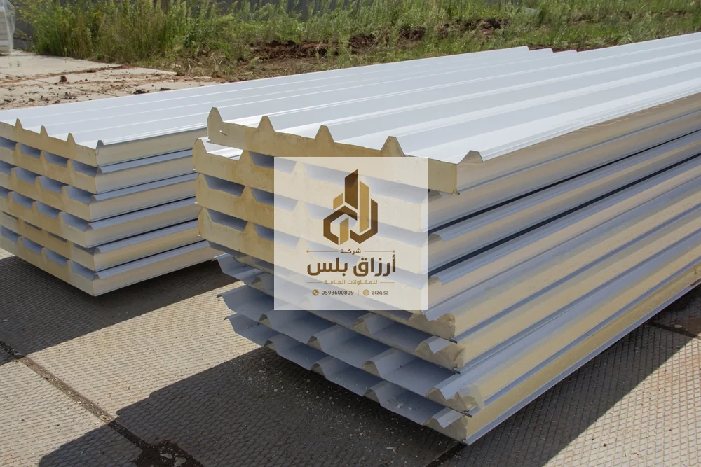كومة مرتّبة من ألواح أسقف الساندوتش بانل في الخارج يظهر فيها القلب الرغوي وتضليع الوجه العلوي