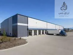 مستودع بواجهة زرقاء وبيضاء وشاحنة عند المنصة
