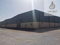 مستودع معدني صغير بواجهة رمادية وسقف مائل