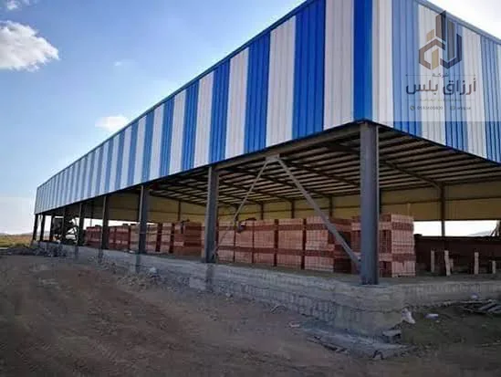مظلة تخزين مفتوحة بسقف معدني مخطط بالأزرق والأبيض